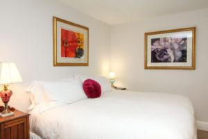 cut glass room with bed, chairs, wall hangings
