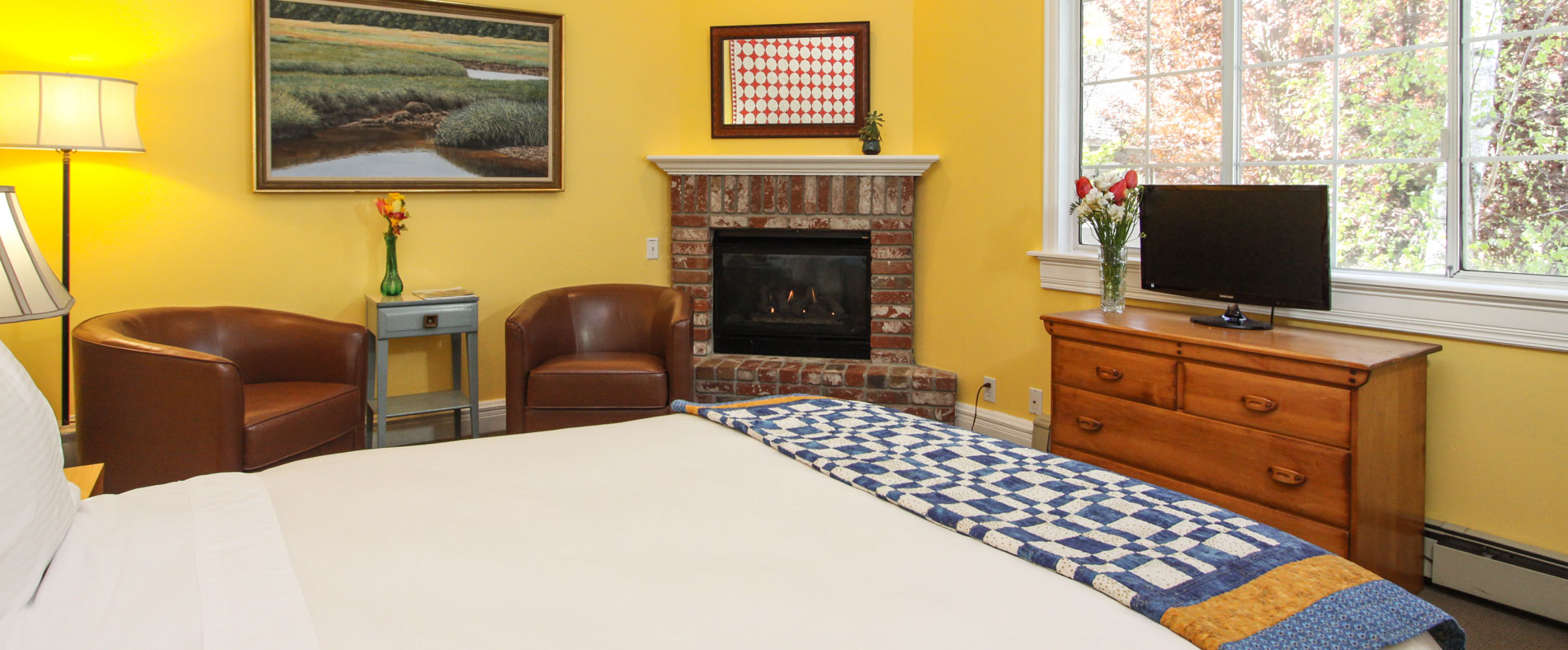 quilt room with fireplace and bed and chairs