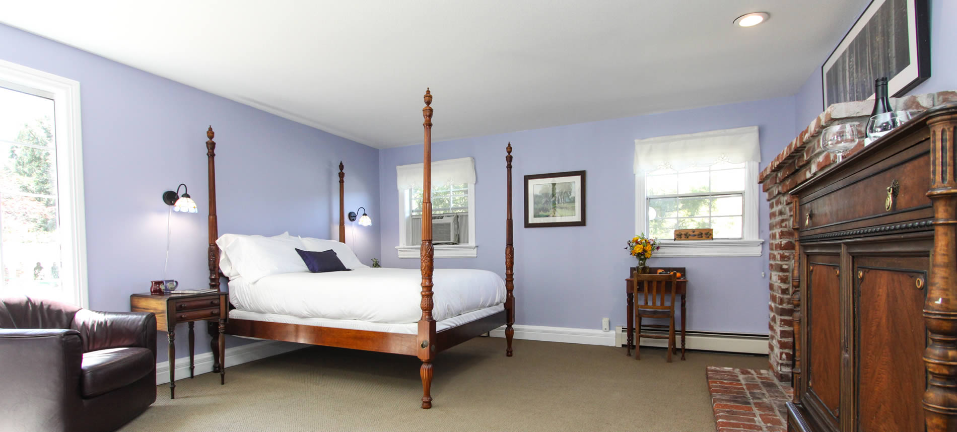 guest room with bed and desk lavender walls