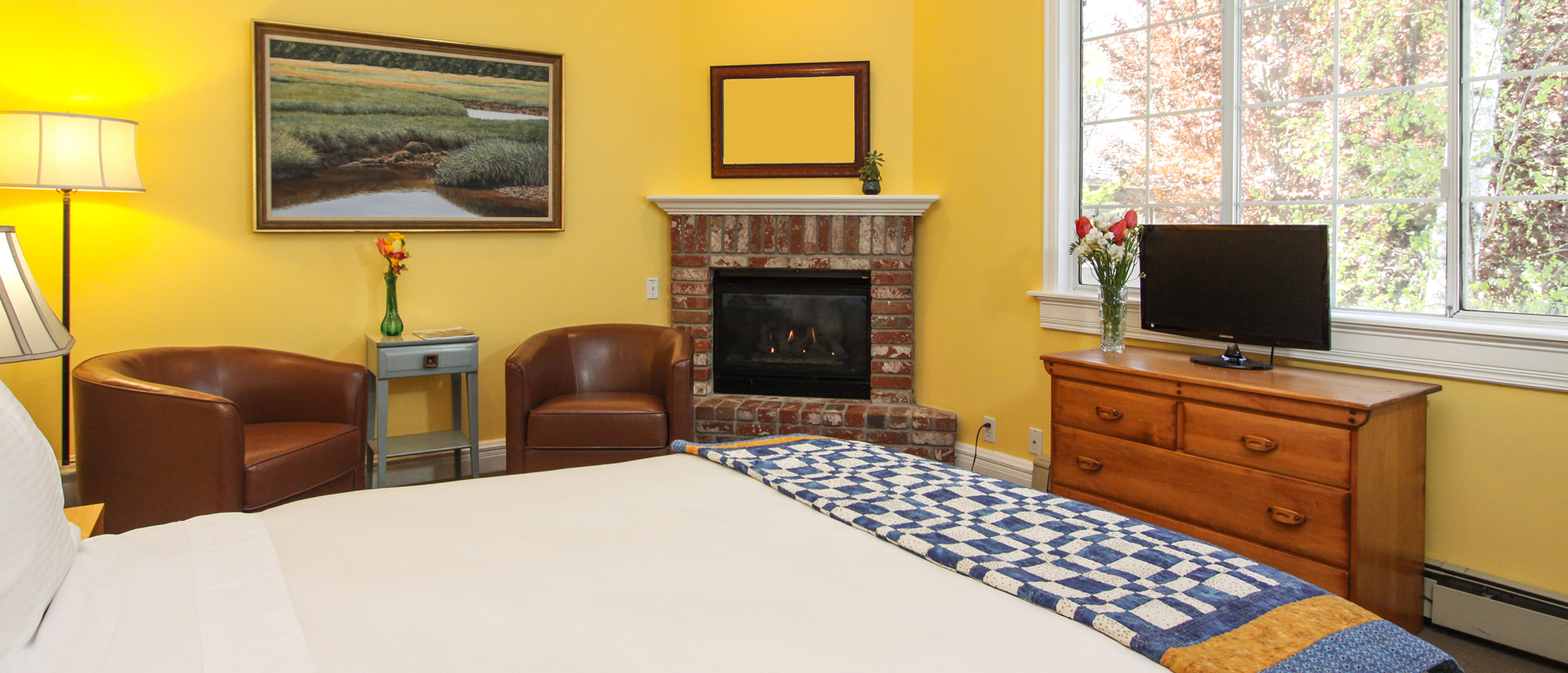 quilt room with fireplace and bed and chairs