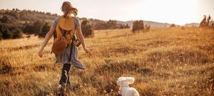 a young woman hiking with her dog